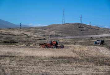 Fototapeta premium harvester harvests wheat on a highland field in the mountains of Armenia