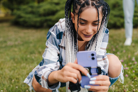 The Girl With The Afro Pigtails Arranges The Phone In Order To Film Herself In A Tik Tok Video. Active Life On The Internet. Followers Drop.