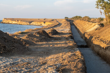 Deep trench in the ground for laying pipes. Water supply or sewerage. Construction site