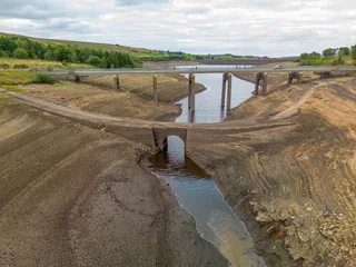 Foto op Plexiglas An old bridge is revealed during at Baitings Reservoir during one of the hottest summers in record UK 2022 © jmh-photography
