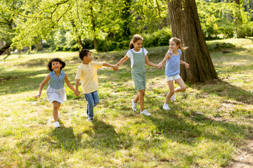 Fototapeta premium Group of asian and caucasian kids having fun in the park