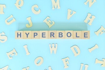 Hyperbole figure of speech concept in English grammar class lesson. Wooden blocks typography flat...