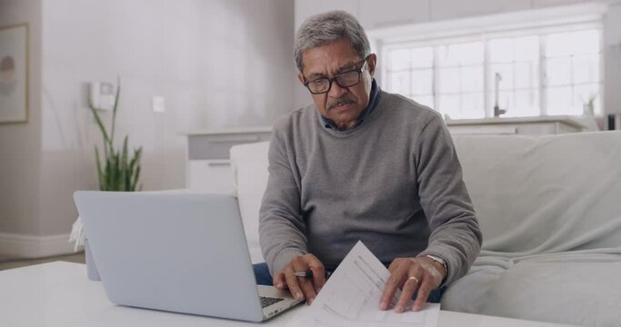 Anxiety, stress and debt by mature man checking finance on a laptop at home. Worried senior male feeling pressure, concerned about budget and financial planning. Older guy stressed about retirement