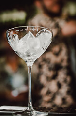 Ice cube in an empty glass on a bar counter in bar or pub