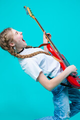 Closeup of Expressive Caucasian Teenager Guitar Player With Red Shiny Bass Guitar Posing In Casual White Shirt Showing Pleased Expression On Turquoise