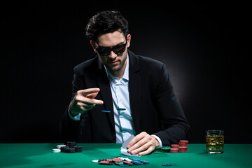 Caucasian Brunet Pocker Player At Pocker Table With Chips and Cards While Thoughfully Sitting With Heap of Cards.