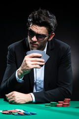 Caucasian Brunet Pocker Player At Pocker Table With Chips and Cards While Thoughfully Sitting
