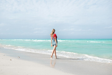 Fototapeta na wymiar Beautiful young woman walking on the beach Varadero , Cuba