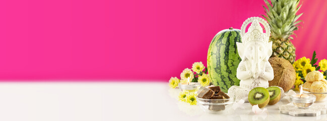 Lord Ganesha , Ganesh festival. Ganesh Chaturthi holiday banner with sculpture of Ganesha, offerings, fruits, sweets, flowers and candles on hot pink background with copy space. Hindu religion holiday © KRISTINA KUPTSEVICH