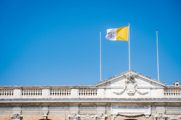 Loreto, the flag of the Vatican city flies over the buildings of the sanctuary - 524222897