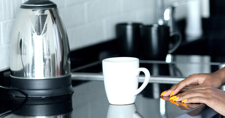 Pure water boils in an electric kettle on the table in the kitchen. 