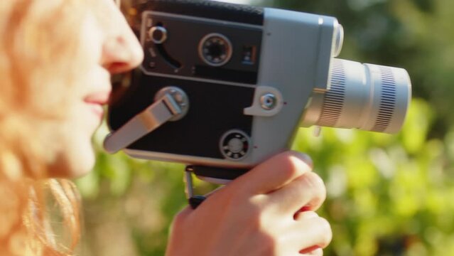 Girl shoots with super 8mm camera in the countryside
