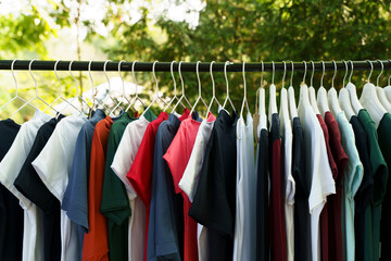 Colored clothes, T-shirts, on hangers in the market.