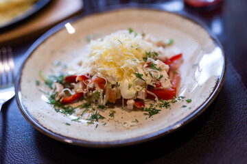 Fresh salad with chicken, vegetables and grated cheese on plate