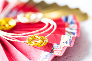 日本の正月　華やかな水引飾りのついた扇のデザイン（白い和紙の背景）
