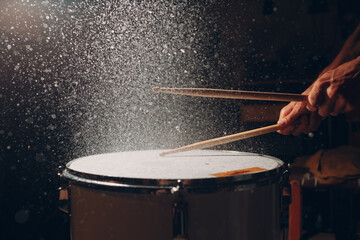 Close up drum sticks drumming hit beat rhythm on drum surface with splash water drops