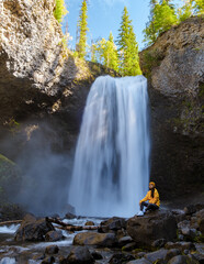 Beautiful waterfall in Canada, couple visit Helmcken Falls, the most famous waterfall in Wells Gray...