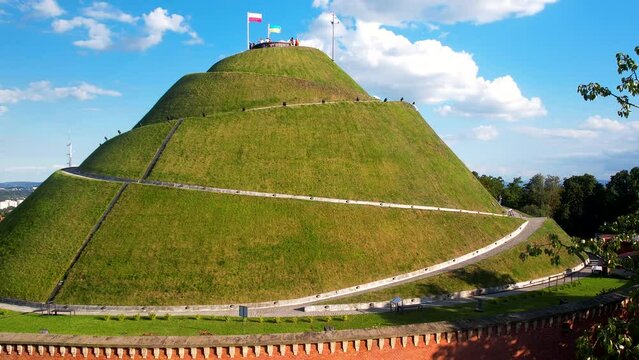 Aerial view of Kościuszko Mound with waving Ukrainian and polish flag during sunny day and blue sky in Krakow,Poland