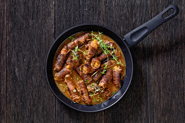 german beef rouladen in thick gravy on pan
