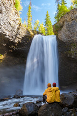 Beautiful waterfall in Canada, couple visit Helmcken Falls, the most famous waterfall in Wells Gray...