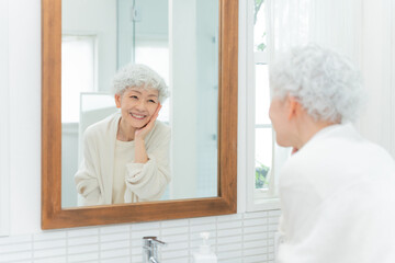 洗面所で鏡を見るシニア女性（美容・ビューティー）