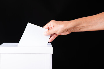 Voting on election day. Caucasian white woman hand putting blank ballot in box