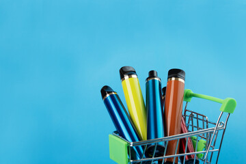 vape in a trolley on a blue background,smoking accessories, copy space