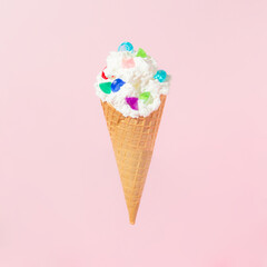 Colorful jewelry diamonds in ice cream cone on pastel background. Minimal wealth concept.