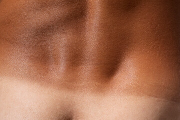 Fototapeta na wymiar Tanned skin macro detail texture, lower back male body close up, tan line