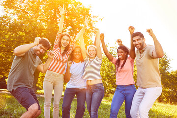 Glückliche Gruppe als erfolgreiches Team jubelt im Park