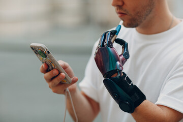 Young disabled man smoke electronic cigarette with artificial prosthetic hand in casual clothes