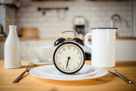 intermittent fasting concept alarm clock on kitchen table