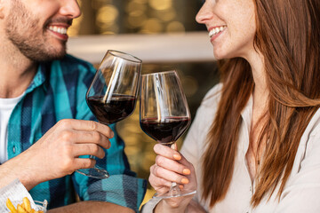 leisure, drinks and people concept - close up of happy couple drinking red wine at restaurant