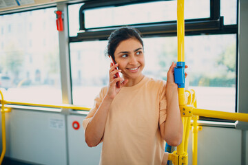 Indian Woman ride in public transport bus or tram with mobile phone