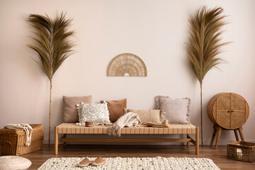 Boho and cozy interior of meditation room with beige chaise lounge, carpet, rattan commode,...