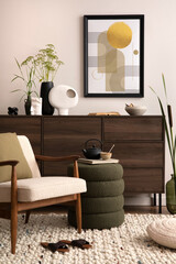 Interior design of harmonized living room with brown commode, design boucle armchair, coffee table pouf, decoration, mock up poster frame and elegant personal accessories. Modern home decor. Template.
