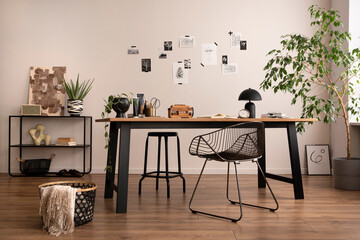 Aesthetic interior of home office interior with design chair, wooden desk, plants, shelf, office accessories, post cards, photos and decoration. Minimalist home decor. Template.	