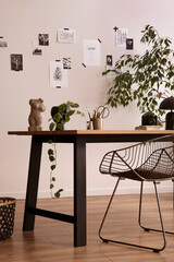 Stylish composition of cozy office interior with black chair, wooden table, plants, office accessories, post cards, decorations and personal accessories. Modern home decor. Template.