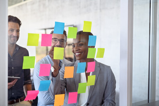 Business people using post it notes to share ideas