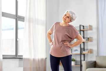 sport, fitness and healthy lifestyle concept - smiling senior woman exercising at home