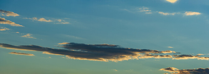 Long elongated stratus clouds against the sky and sunset.