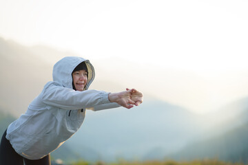 A muslim woman does exercises in the mountains