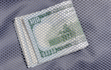 A pack of hundred dollar bills in a transparent pocket. Cash stash. Stack of cash.