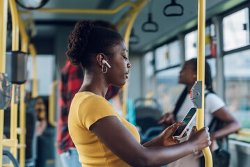 African american woman riding a bus and using a smartphone