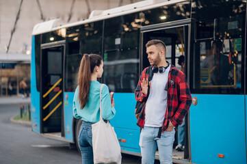 Two friends waiting for a public transport at a bus stop