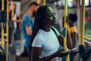 African american woman using smartphone while riding a bus in the night