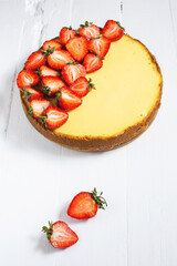 Sweet breakfast, delicious cheesecake with fresh strawberries, homemade recipe on a white wooden table.