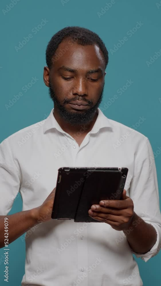 Poster vertical video: businessman working on digital tablet to browse internet, using wireless portable ga