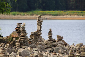 Fototapeta na wymiar pyramids of stones on the river Daugava
