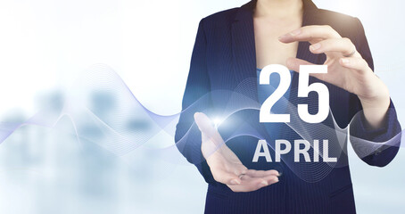 April 25th. Day 25 of month, Calendar date. Hand hold virtual hologram calendar date with digital...